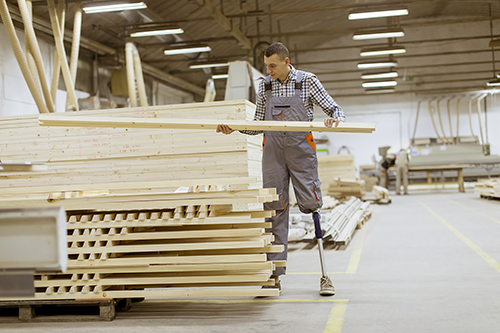Man with artificial leg working at a warehouse